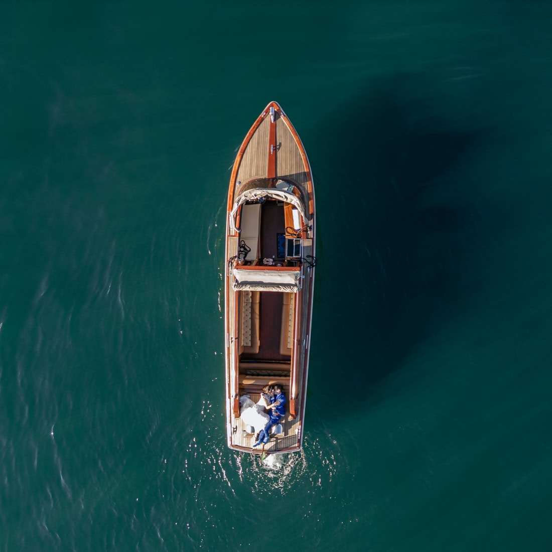 Drone shot of a luxury wooden Venetian taxi boat near Bellagio Lake Como